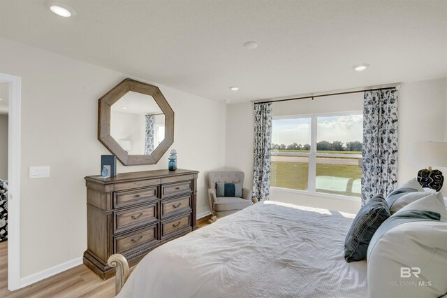 bedroom with baseboards, wood finished floors, and recessed lighting