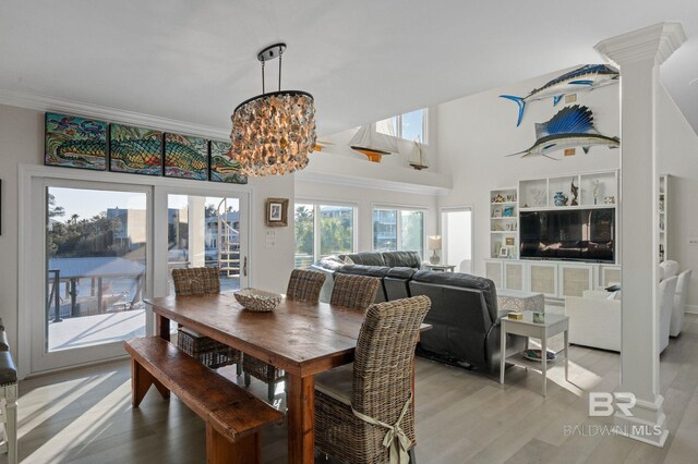 30471 Harbour Dr, Orange Beach, AL 36561 - dining space featuring crown molding, a notable chandelier, and light wood finished floors