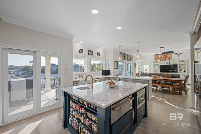30471 Harbour Dr, Orange Beach, AL 36561 - kitchen featuring an island with sink, open floor plan, light wood-type flooring, and a warming drawer