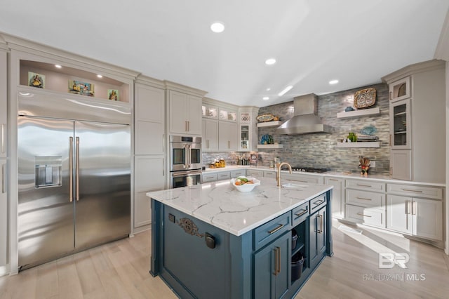 30471 Harbour Dr, Orange Beach, AL 36561 - kitchen featuring wall chimney range hood, light wood-type flooring, decorative backsplash, stainless steel appliances, and open shelves