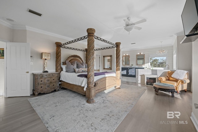 30471 Harbour Dr, Orange Beach, AL 36561 - bedroom with visible vents, ornamental molding, ceiling fan with notable chandelier, wood finished floors, and ornate columns
