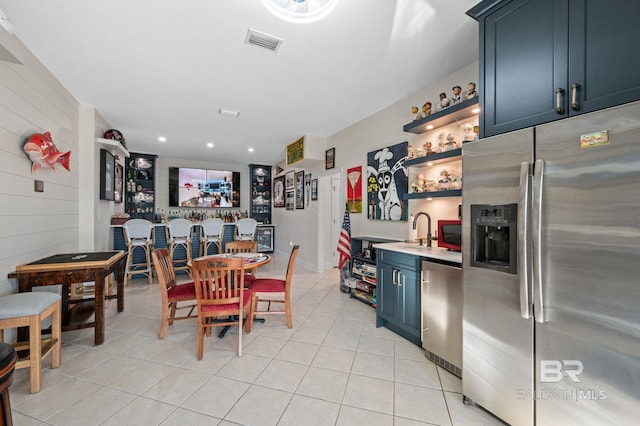30471 Harbour Dr, Orange Beach, AL 36561 - dining room with wet bar, light tile patterned flooring, visible vents, and wood walls