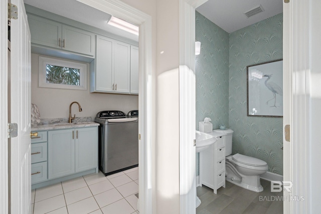 30471 Harbour Dr, Orange Beach, AL 36561 - bathroom featuring visible vents, wallpapered walls, separate washer and dryer, tile patterned floors, and toilet