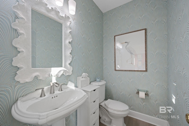 30471 Harbour Dr, Orange Beach, AL 36561 - half bathroom featuring a sink, toilet, wood finished floors, and wallpapered walls