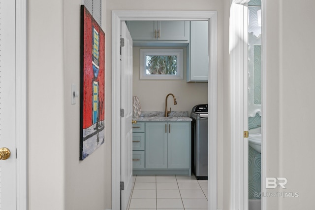 30471 Harbour Dr, Orange Beach, AL 36561 - kitchen with washer / dryer, light tile patterned floors, light stone countertops, and a sink