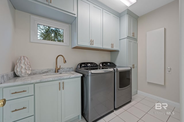 30471 Harbour Dr, Orange Beach, AL 36561 - washroom featuring washer and clothes dryer, a sink, cabinet space, light tile patterned floors, and baseboards