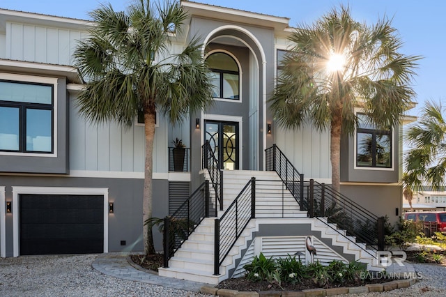 30471 Harbour Dr, Orange Beach, AL 36561 - view of exterior entry featuring a garage, board and batten siding, driveway, and stucco siding