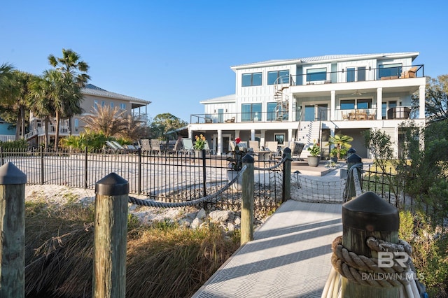 30471 Harbour Dr, Orange Beach, AL 36561 - view of front of property featuring a patio, stairway, a balcony, fence private yard, and board and batten siding