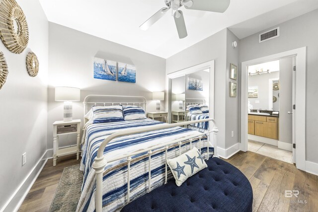28105 Perdido Beach Blvd Unit C-314, Orange Beach, AL 36561 - bedroom with connected bathroom, baseboards, visible vents, and wood finished floors