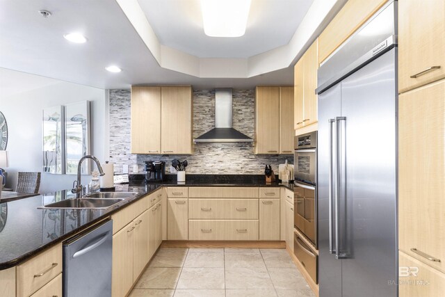 28105 Perdido Beach Blvd Unit C-314, Orange Beach, AL 36561 - kitchen with wall chimney range hood, light brown cabinetry, appliances with stainless steel finishes, a sink, and decorative backsplash