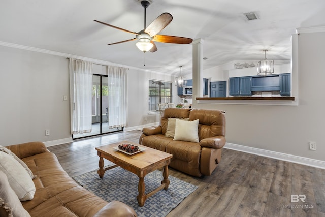 living room with crown molding, ornate columns, hardwood / wood-style floors, vaulted ceiling, and ceiling fan with notable chandelier