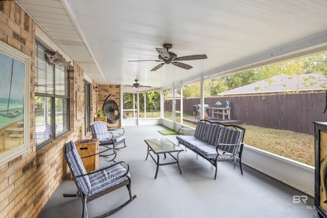 sunroom featuring ceiling fan and plenty of natural light