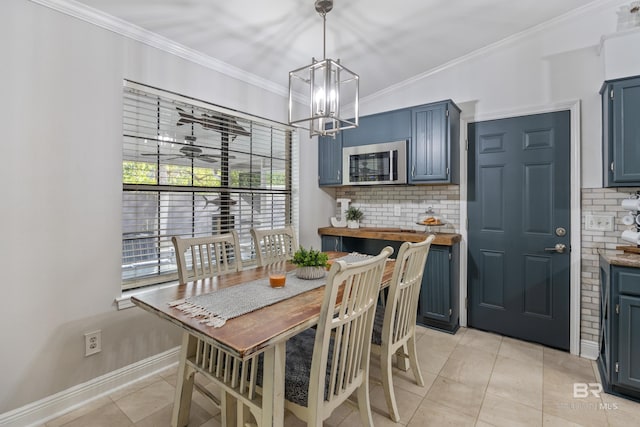 tiled dining space featuring crown molding and a notable chandelier