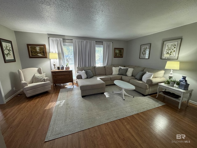 living room featuring a textured ceiling, baseboards, and wood finished floors
