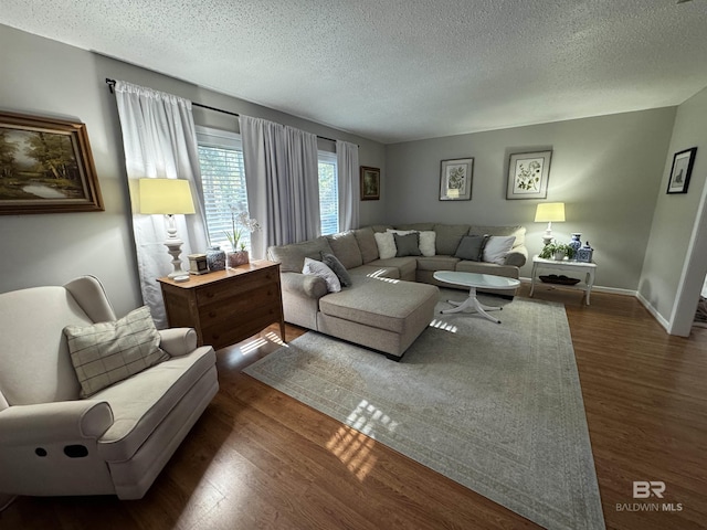 living room with a textured ceiling, wood finished floors, and baseboards