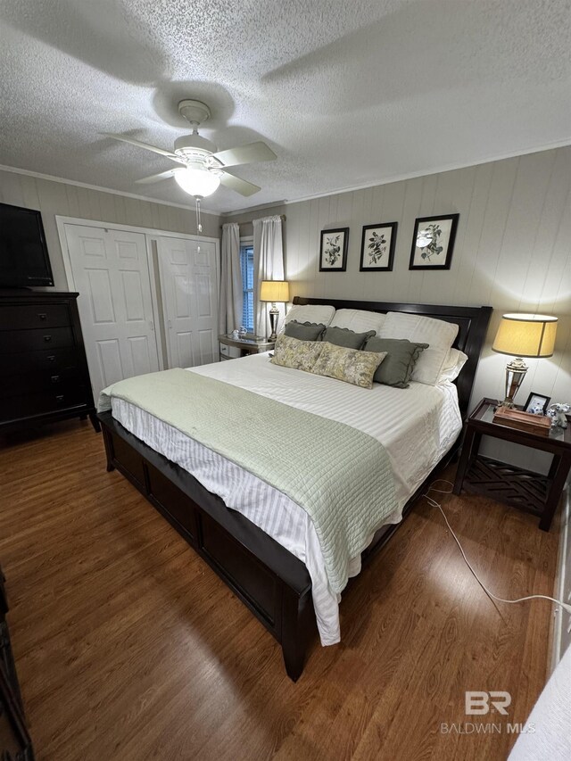 bedroom featuring a ceiling fan, a closet, a textured ceiling, and wood finished floors