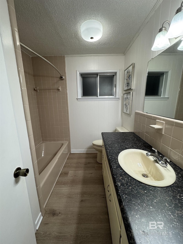 full bath with toilet, tub / shower combination, vanity, a textured ceiling, and wood finished floors