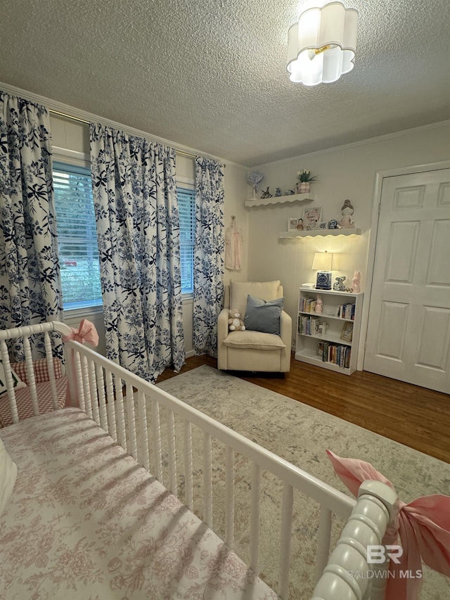 bedroom with a textured ceiling and wood finished floors