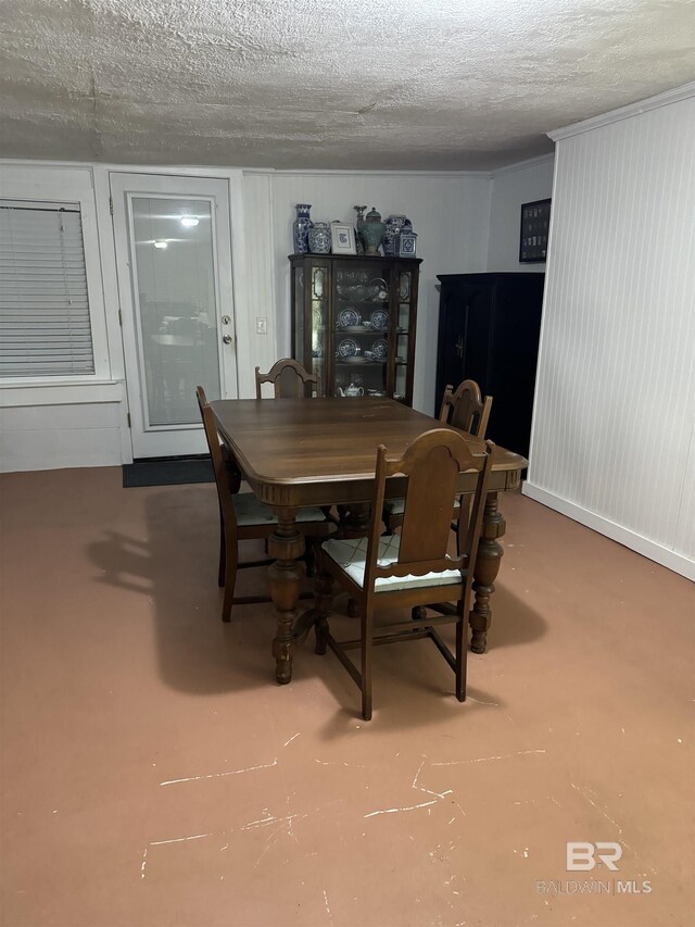 dining area featuring a textured ceiling and finished concrete floors