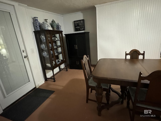 carpeted dining room with a textured ceiling