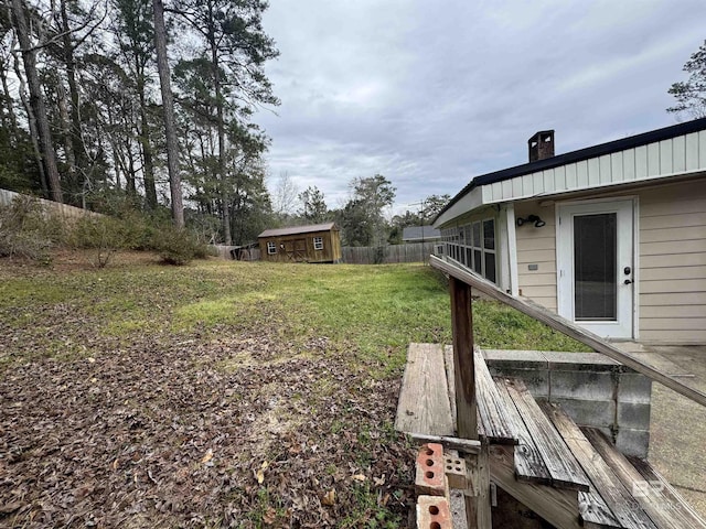 view of yard featuring an outbuilding and fence