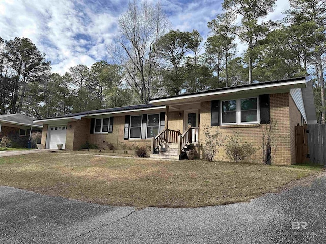 single story home with a garage, brick siding, and fence