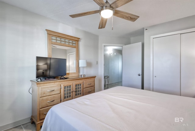 bedroom with light tile patterned floors, a ceiling fan, and a closet