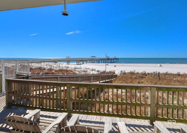 wooden deck with a beach view and a water view