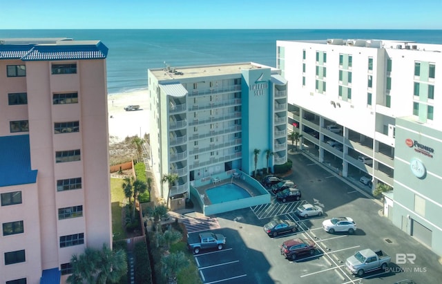 view of building exterior featuring uncovered parking and a water view