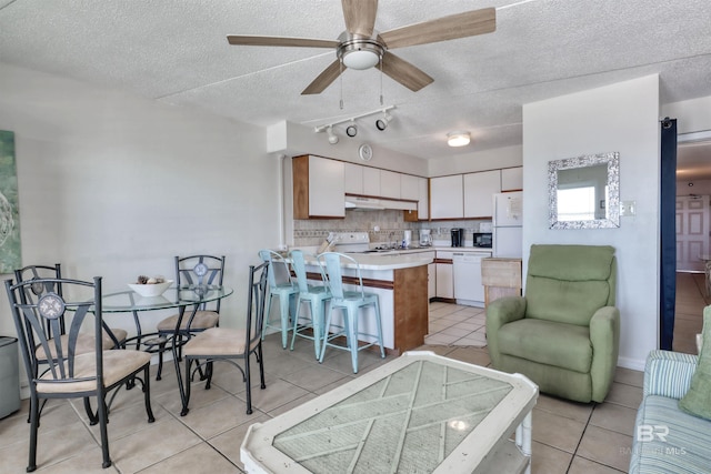 dining room with ceiling fan, a textured ceiling, and light tile patterned floors