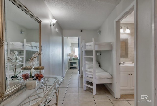 bathroom featuring a textured ceiling, baseboards, vanity, and tile patterned floors