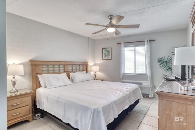 bedroom with light tile patterned floors, ceiling fan, a textured ceiling, and an AC wall unit