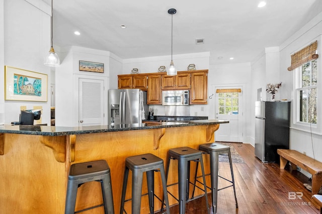 25773 Canal Rd Unit 28, Orange Beach, AL 36561 - kitchen with visible vents, dark wood finished floors, decorative light fixtures, brown cabinets, and appliances with stainless steel finishes