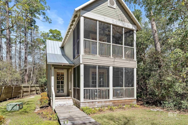 25773 Canal Rd Unit 28, Orange Beach, AL 36561 - view of front of house with metal roof, fence, a front lawn, and a sunroom