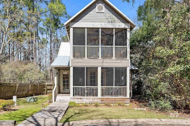 25773 Canal Rd Unit 28, Orange Beach, AL 36561 - view of front of house featuring metal roof, fence, a front yard, and a sunroom