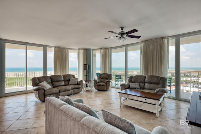 living room featuring light tile floors, a wealth of natural light, ceiling fan, and a water view