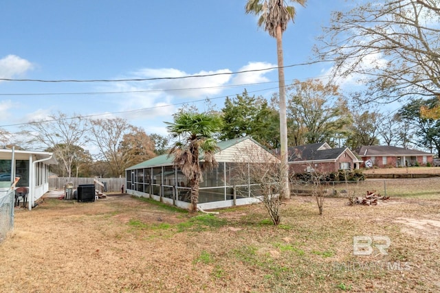 view of yard featuring a sunroom and central AC