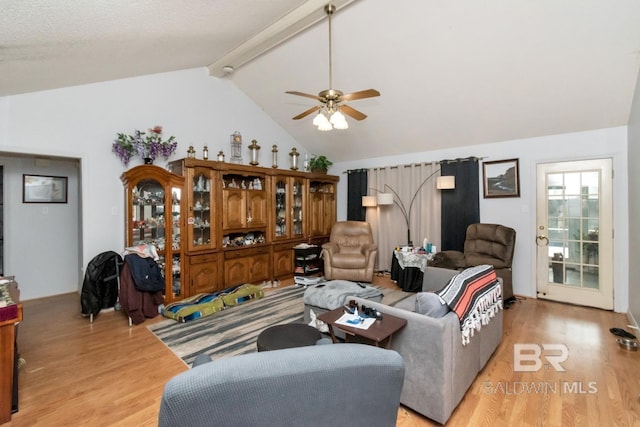 living room with vaulted ceiling with beams, light hardwood / wood-style floors, and ceiling fan