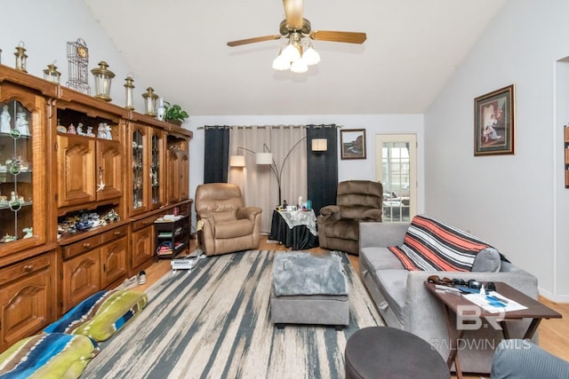 living room featuring ceiling fan, lofted ceiling, and light hardwood / wood-style flooring