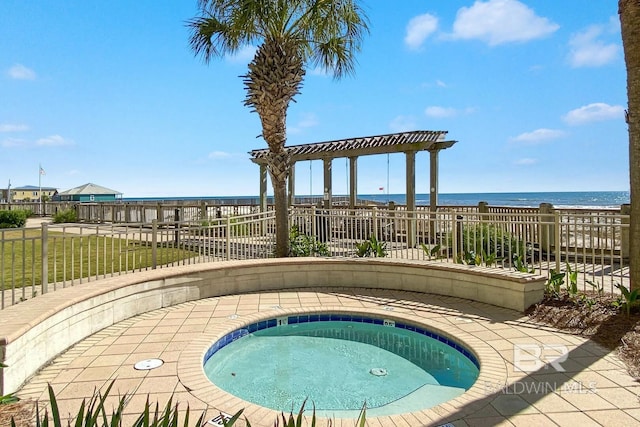 view of swimming pool featuring a water view, an in ground hot tub, fence, and a lawn