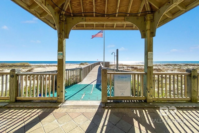 deck featuring a water view and a beach view