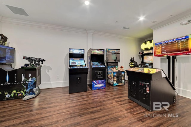 recreation room featuring baseboards, visible vents, crown molding, and wood finished floors
