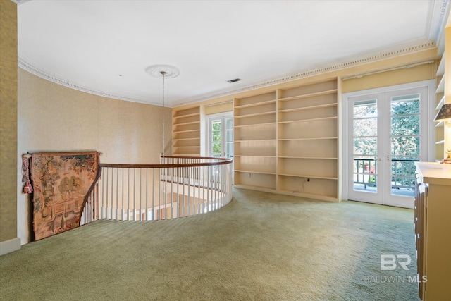 empty room with ornamental molding, french doors, and carpet