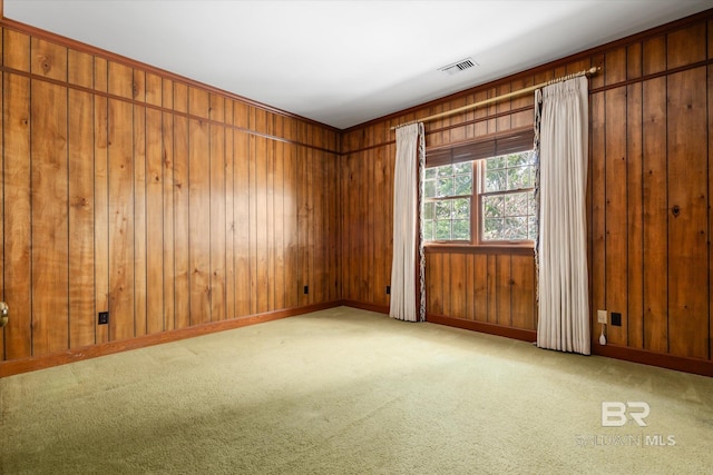 carpeted spare room featuring wood walls