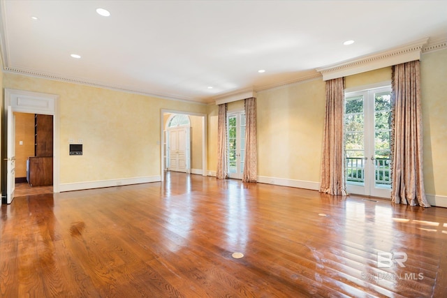 empty room with ornamental molding, french doors, and wood-type flooring