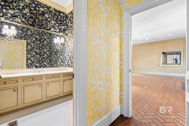 bathroom with vanity, a chandelier, and ornamental molding