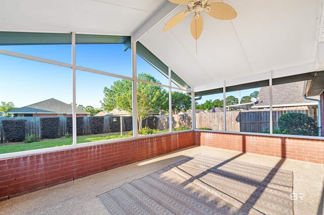 unfurnished sunroom featuring beamed ceiling and a ceiling fan