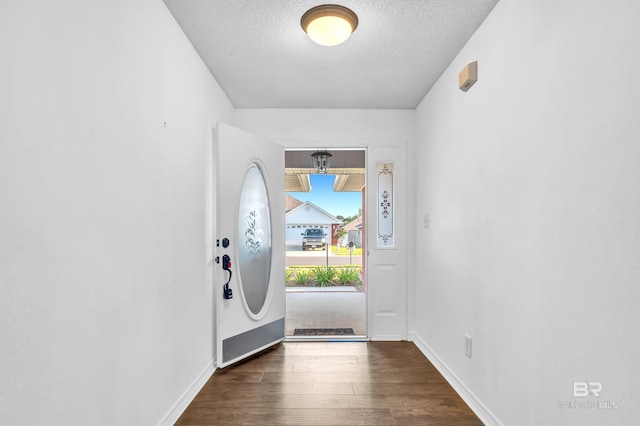entryway featuring baseboards, wood finished floors, and a textured ceiling