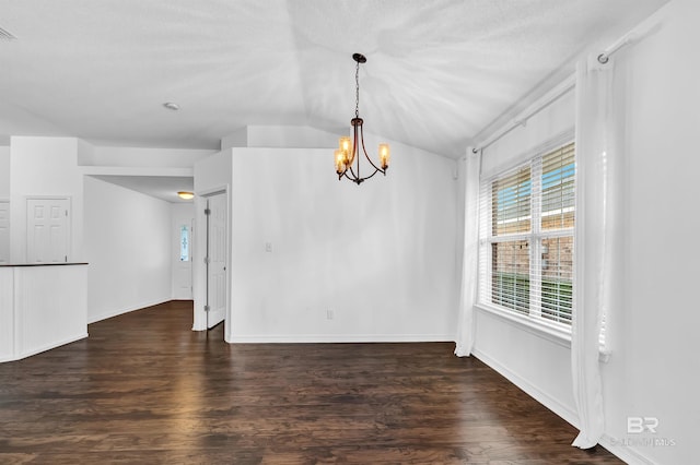 unfurnished dining area with visible vents, vaulted ceiling, wood finished floors, and an inviting chandelier