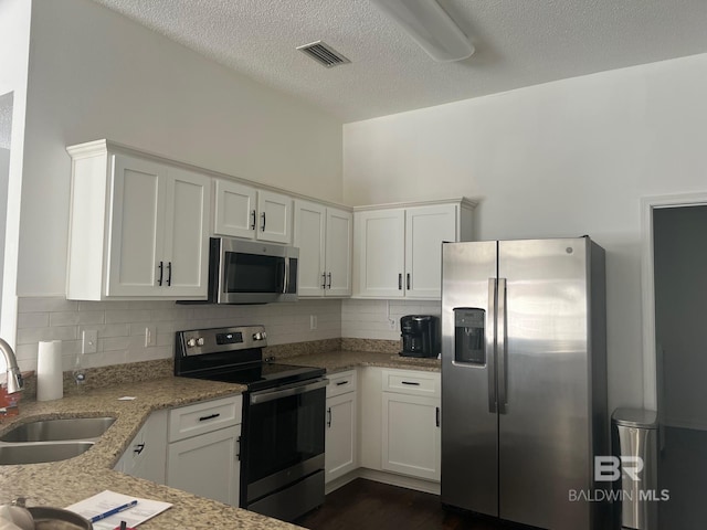 kitchen with decorative backsplash, visible vents, a sink, and appliances with stainless steel finishes